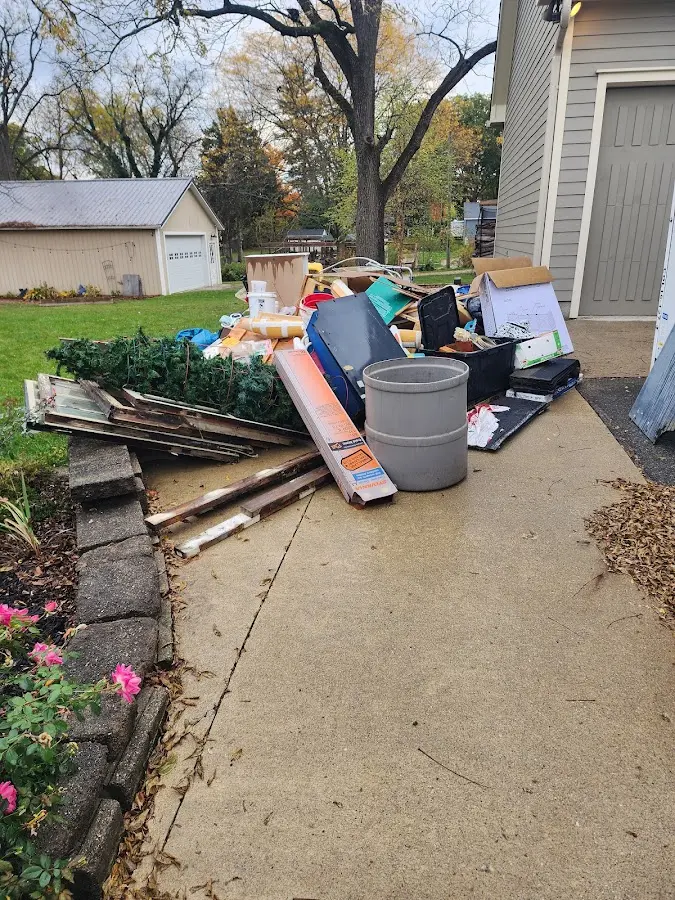 Dumpster being loaded with debris for 12 Yard Dumpster Rental in Estero